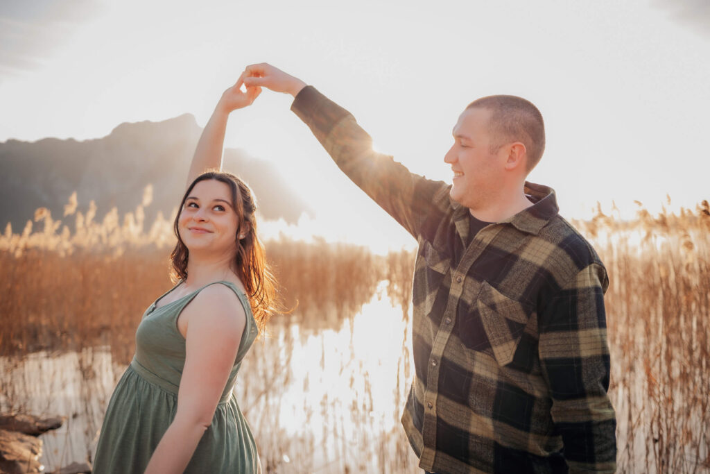 Natürliche Babybauchfotografie am Mondsee. Paar tanzt bei Sonnenuntergang.